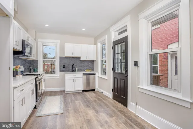 a large kitchen with a large window and stainless steel appliances