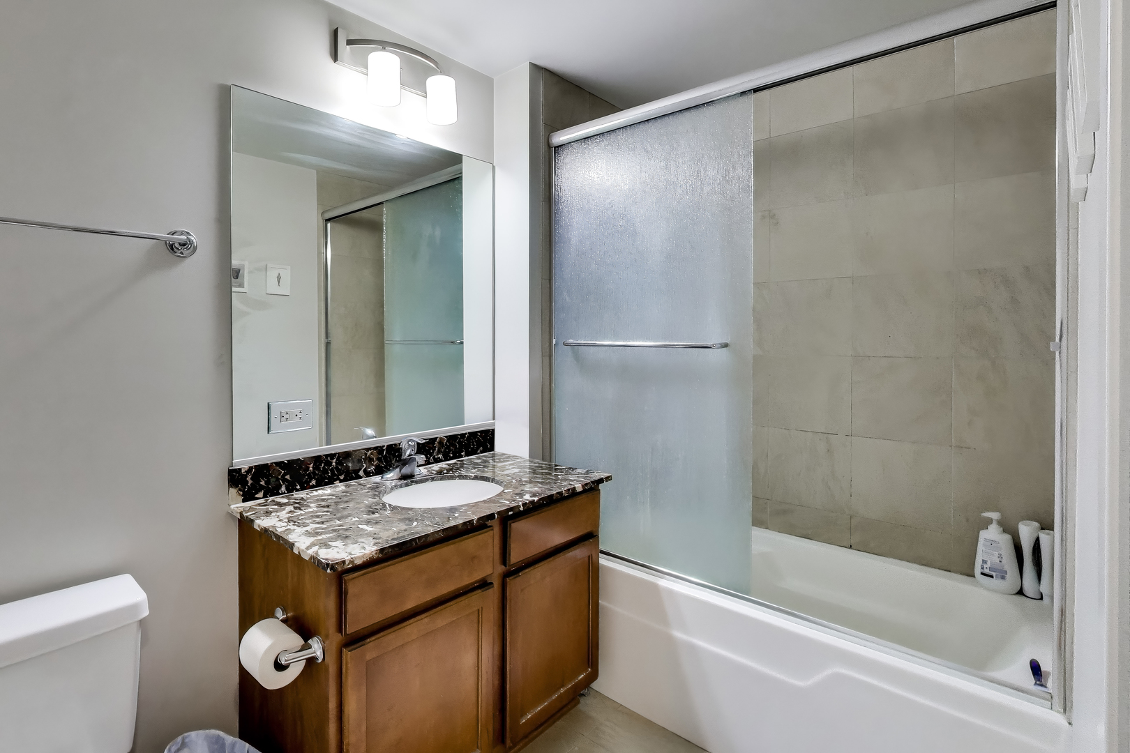 909 West Washington Boulevard, Unit 811 Chicago, IL 60607 - Photo 12 of 28 a bathroom with a granite countertop sink a toilet and shower
