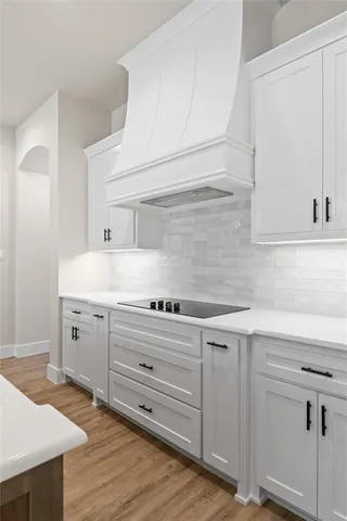 a kitchen with a sink a window and wooden floor