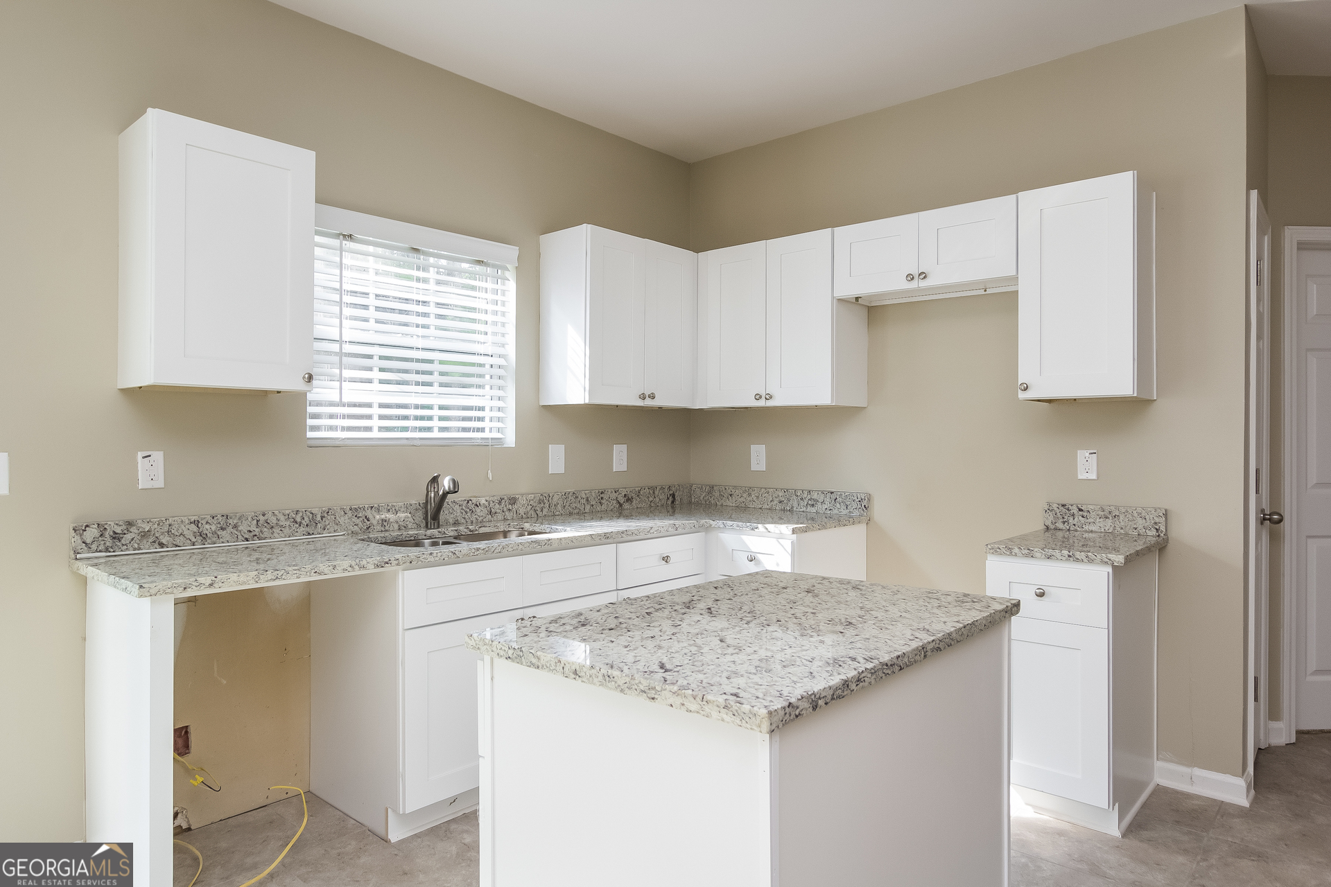 5892 Village Loop Fairburn, GA 30213 - Photo 4 of 15 a kitchen with granite countertop a sink stove and cabinets