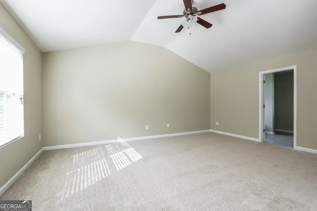 an empty room with a window and a fan