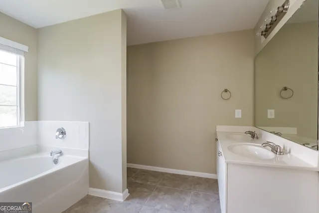 a bathroom with a tub sink and mirror