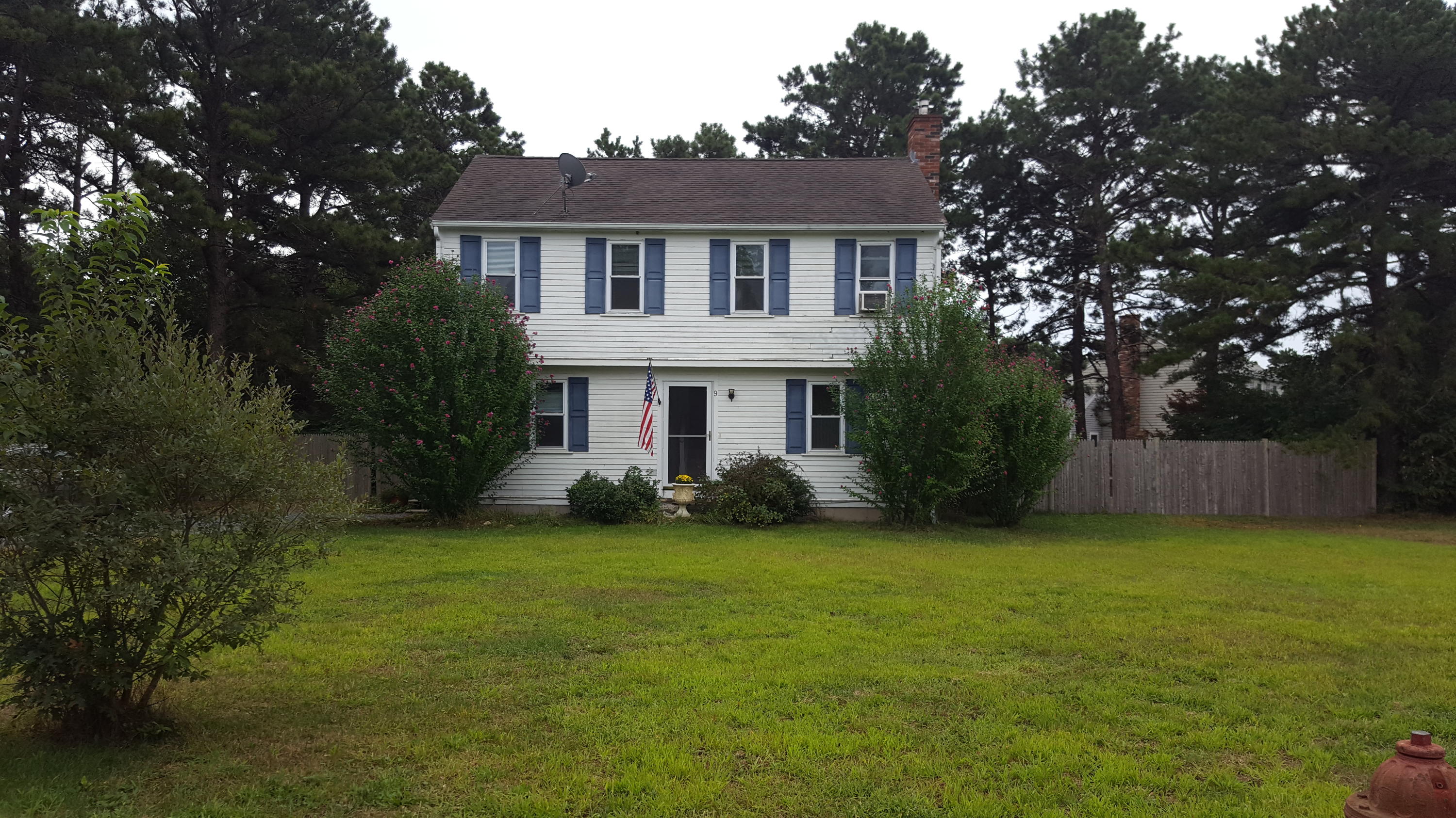 a view of a house with a yard and a tree