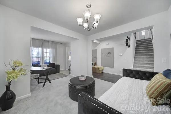 a large kitchen with kitchen island a stove a sink a refrigerator and white cabinets with wooden floor