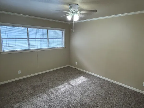 an empty room with a window and a fan