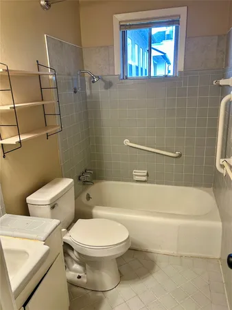 a white toilet and tub sitting next to a bathroom sink