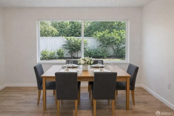 a dining room with furniture window and wooden floor