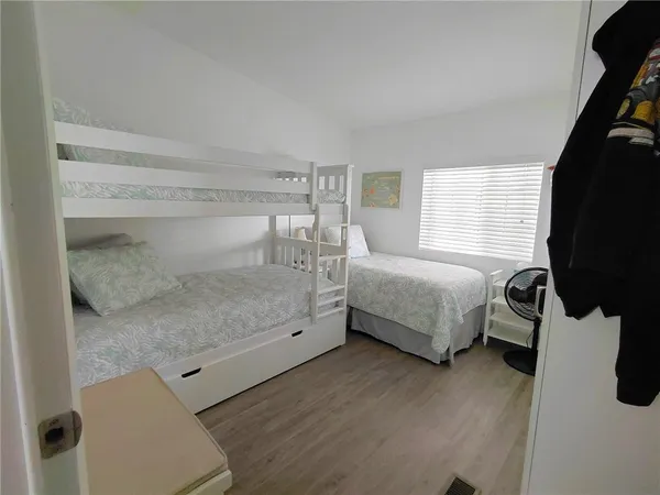 a bedroom with a bed and wooden floor