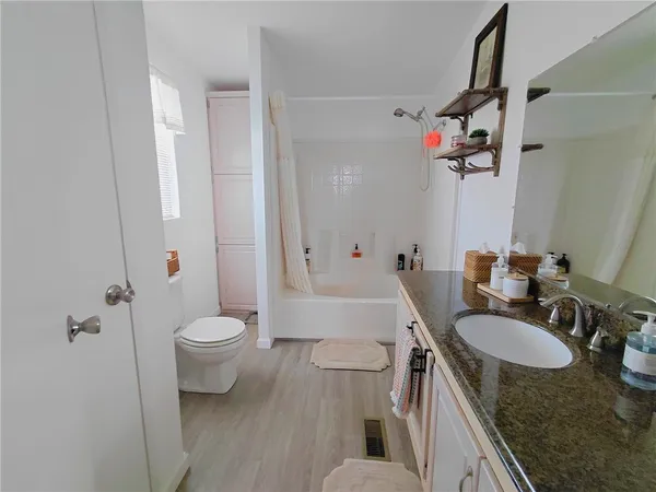 a bathroom with a granite countertop sink toilet and shower