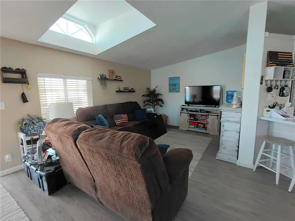 a living room with furniture a flat screen tv and a window