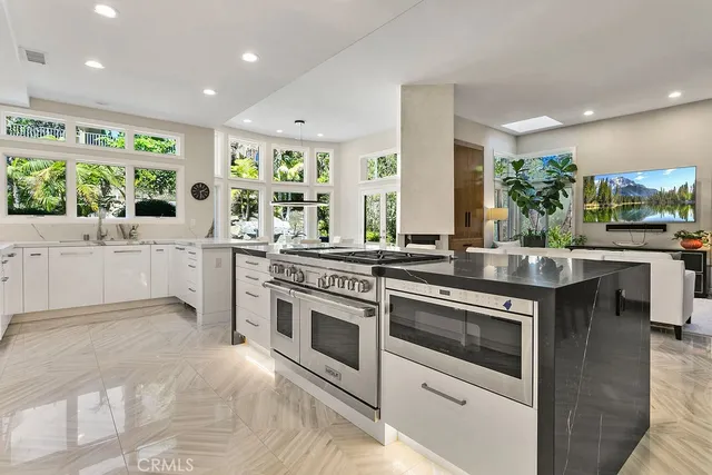 a kitchen with stainless steel appliances kitchen island granite countertop a table and chairs
