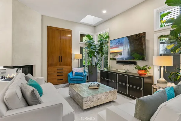 a living room with furniture kitchen view and a chandelier