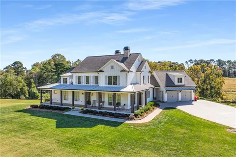 a view of a big house with a big yard and large trees