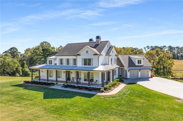 a view of a big house with a big yard and large trees