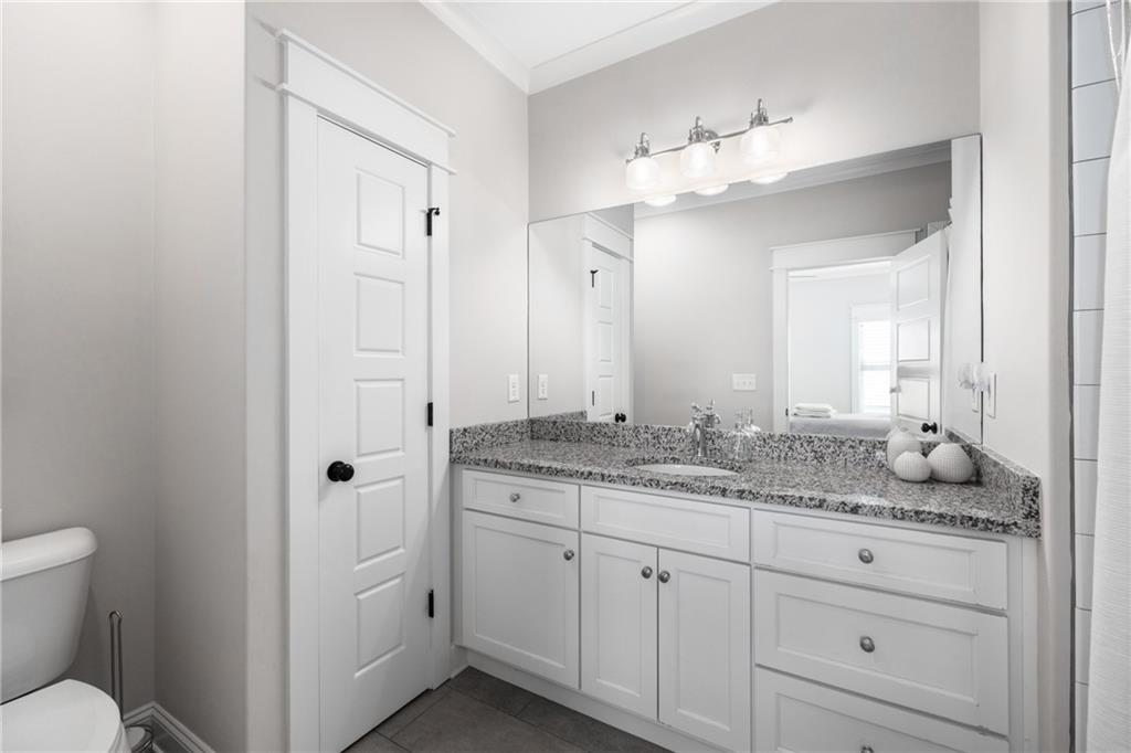 938 Austin Road Winder, GA 30680 - Photo 33 of 50 a bathroom with a granite countertop sink mirror and toilet