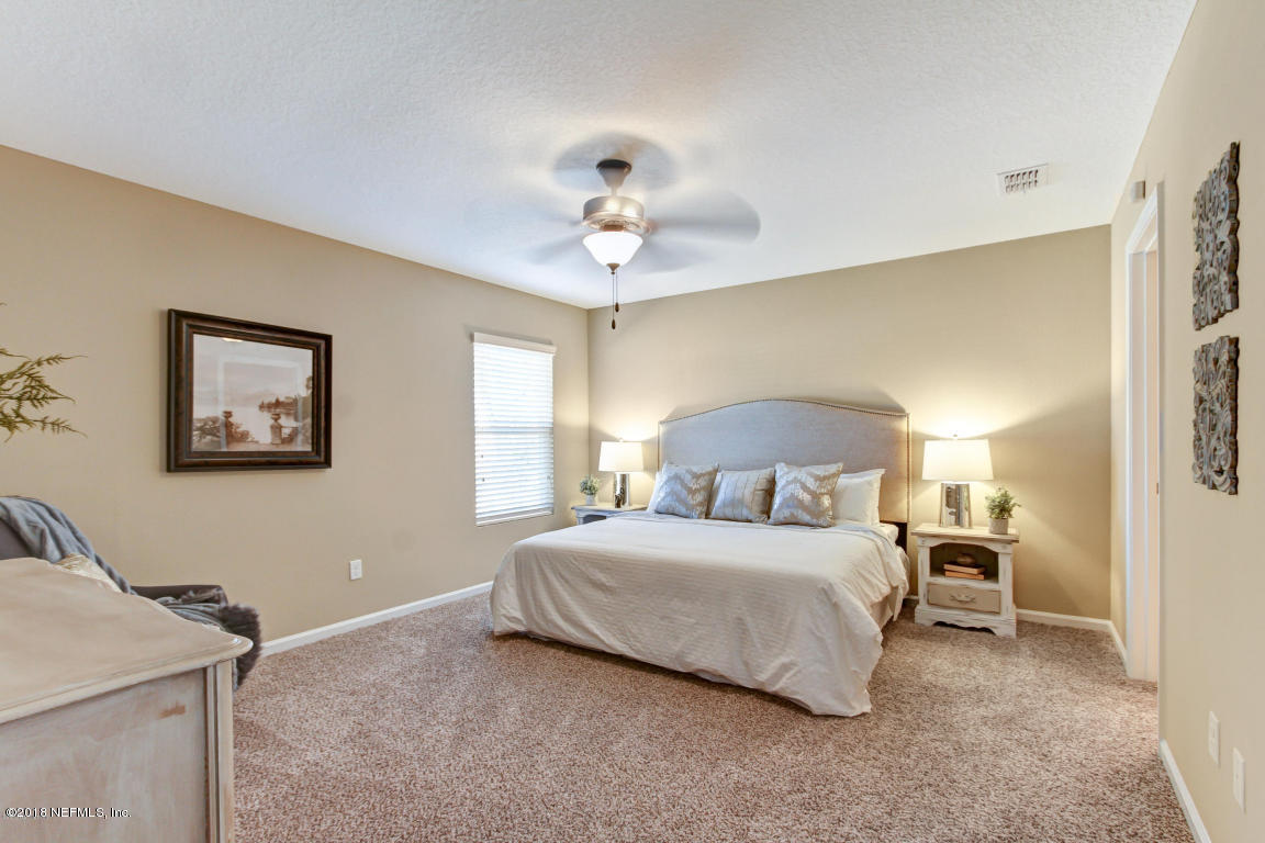 2937 Kent Road Jacksonville, FL 32216 - Photo 17 of 22 a bedroom with a bed and a chandelier