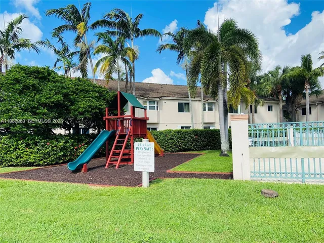 a view of a house with a yard and palm trees