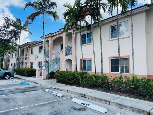 a front view of multiple houses with palm trees