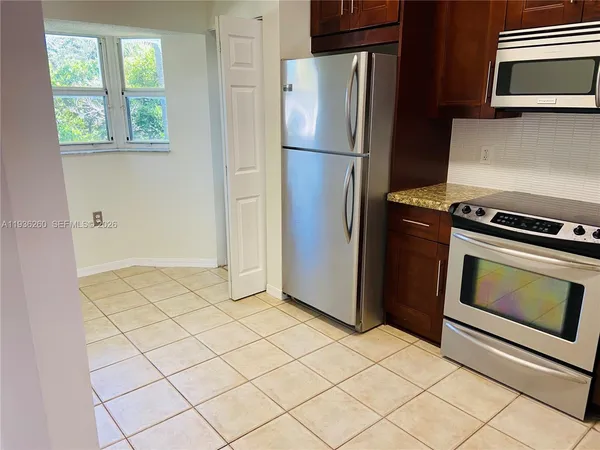 a kitchen with a refrigerator and a stove top oven