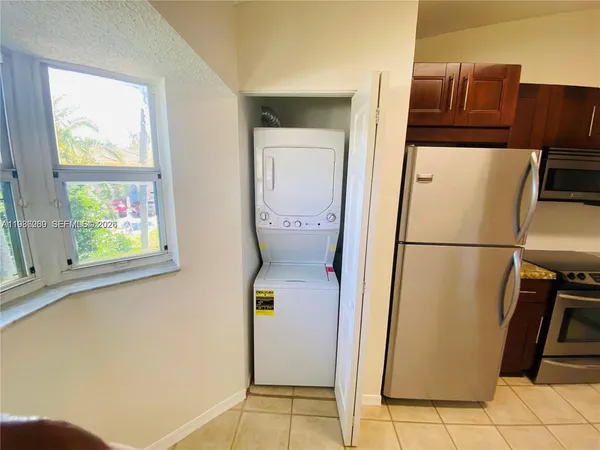 a utility room with refrigerator and washer