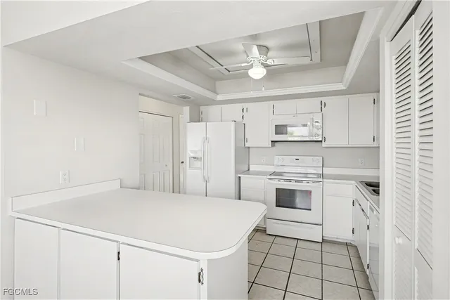 a kitchen with white cabinets and white appliances