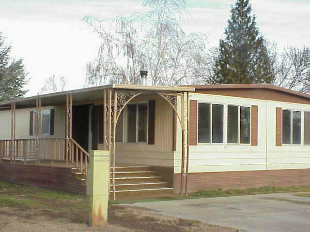 525 Rouse Road, Unit 23 Sunnyside, WA 98944 - Photo 1 of 3 a view of a house with a small yard and wooden fence