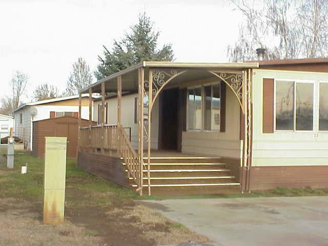 525 Rouse Road, Unit 23 Sunnyside, WA 98944 - Photo 3 of 3 a view of a house with a small yard and wooden fence