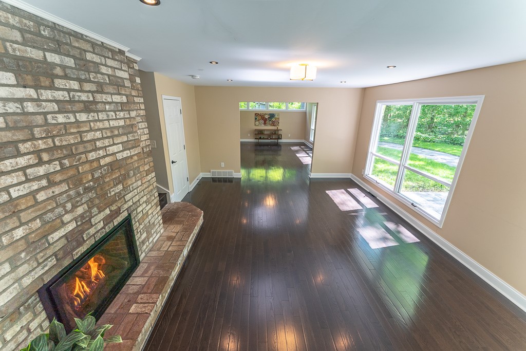 220 Hibiscus Drive Rochester, NY 14618 - Photo 23 of 50 The family room invites you to settle in, anchored by a dramatic floor-to-ceiling brick hearth with a gas fireplace.