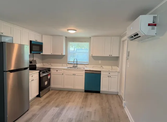 a kitchen with a refrigerator sink and stove top oven