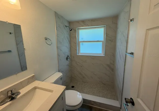 a bathroom with a sink toilet and shower