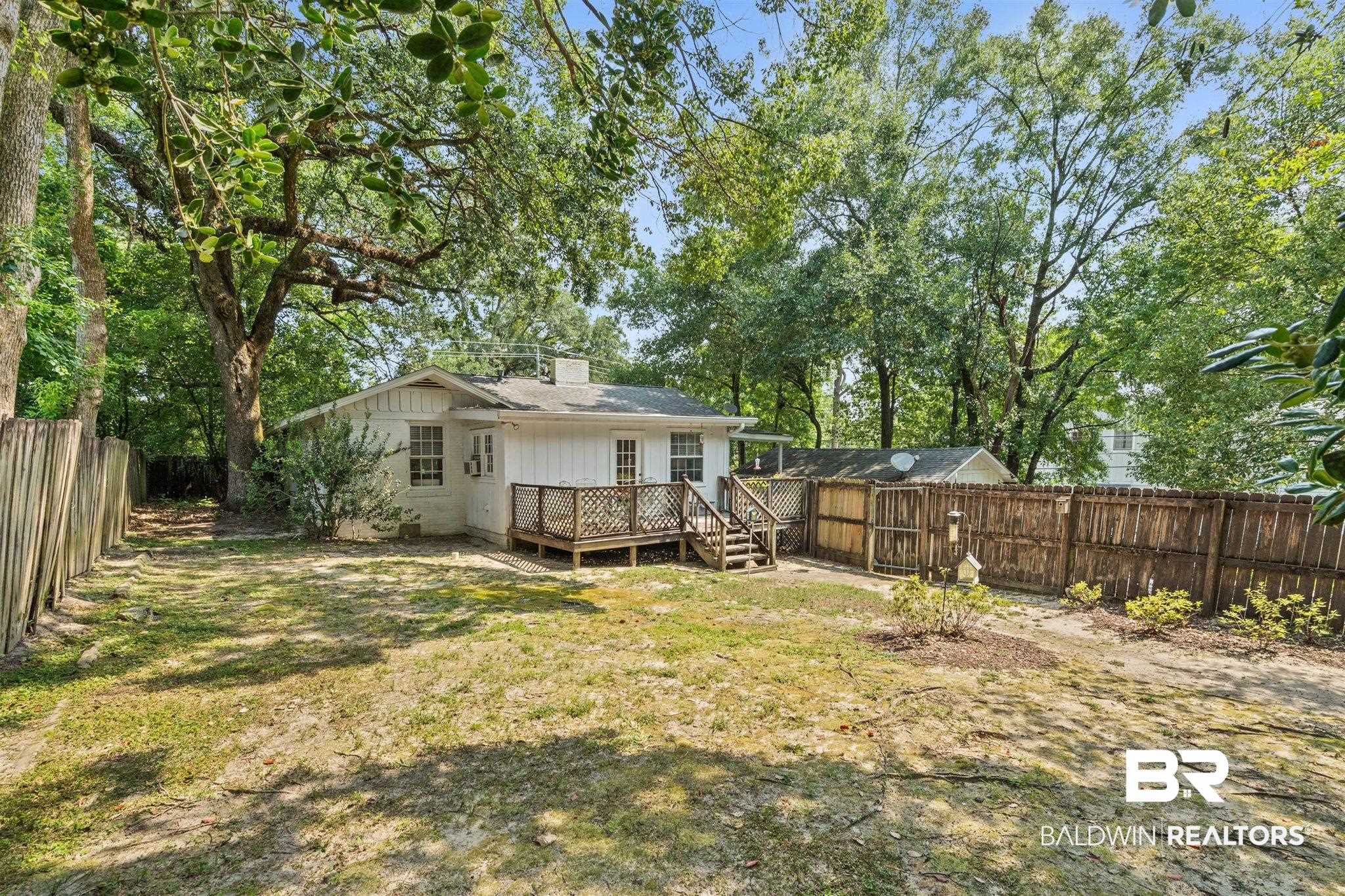 3751 Old Shell Road Mobile, AL 36608 - Photo 18 of 21 Expansive backyard featuring a wood deck, wood fencing, and mature trees providing natural shade