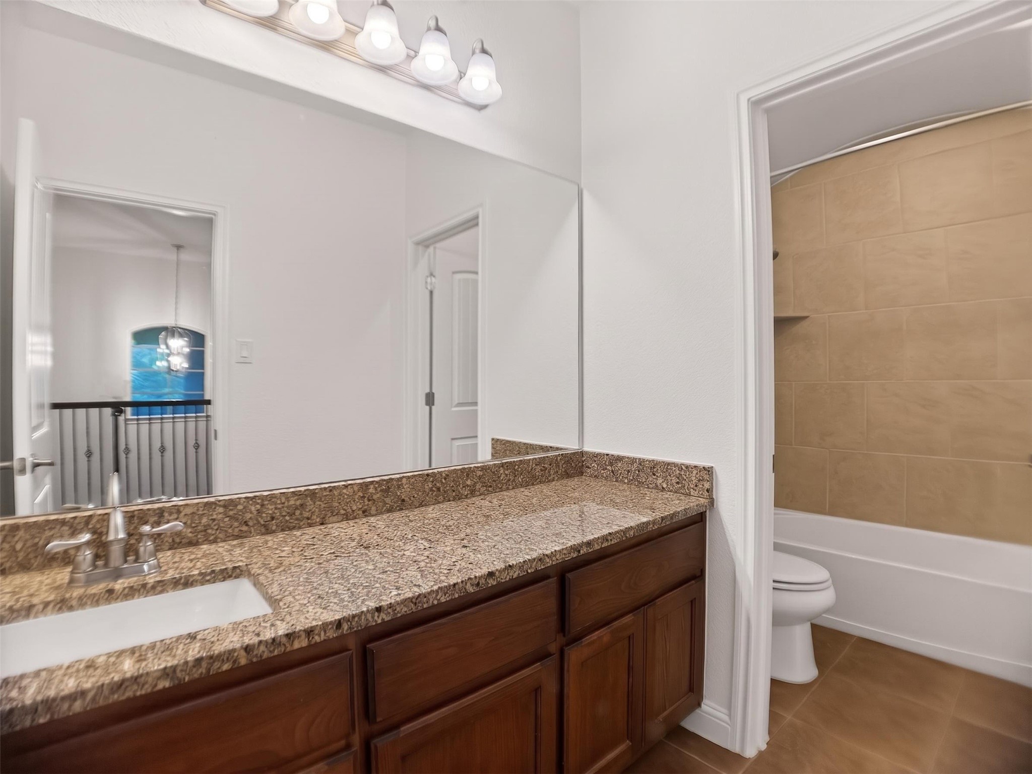 1505 Long Shadow Lane Georgetown, TX 78628 - Photo 17 of 28 Bathroom vanity featuring a granite countertop, undermount sink, and wood-finish cabinetry
