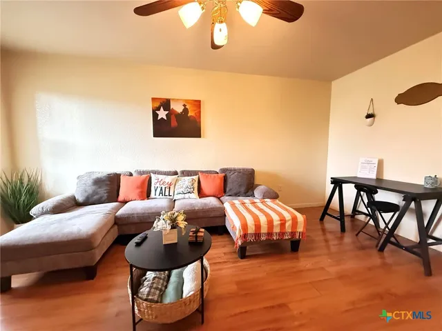 a living room with furniture and a wooden floor