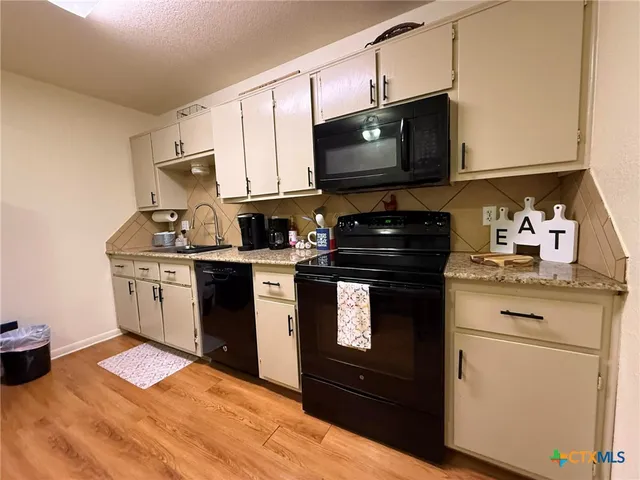 a kitchen with a sink stove and microwave