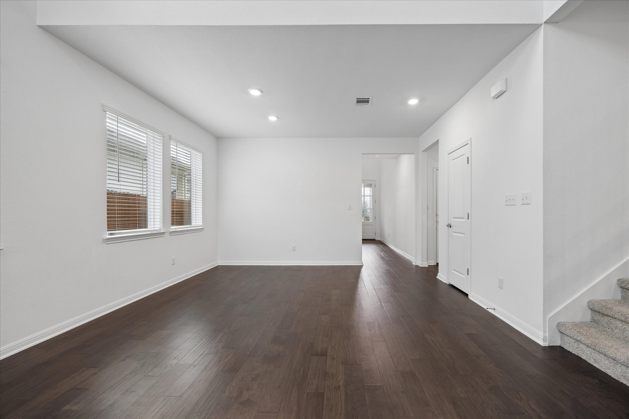 6407 Rounded Pebble Lane Buda, TX 78610 - Photo 7 of 32 Rich hardwood flooring stretches across this naturally illuminated living space, perfect for gathering.