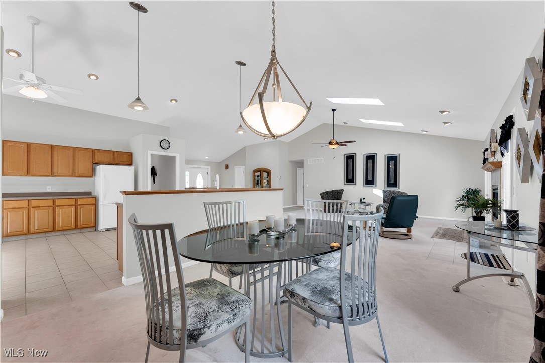 8651 State Road North Royalton, OH 44133 - Photo 11 of 33 Dining area featuring ceiling fan, lofted ceiling, a skylight, light carpet, and light tile patterned floors