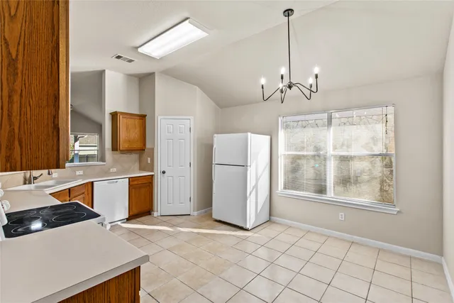 a large kitchen with cabinets wooden floor and stainless steel appliances