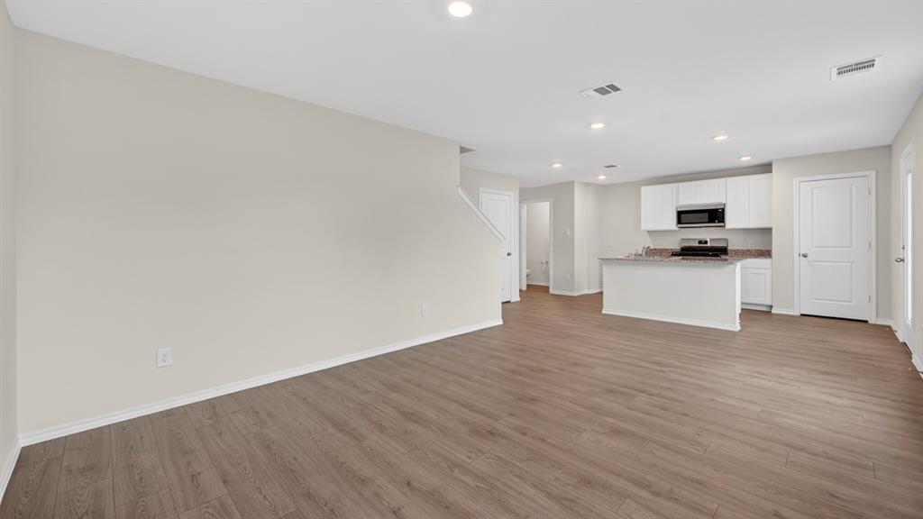3534 Spring Time Street Forney, TX 75126 - Photo 7 of 24 Open-concept living space featuring wood-finish flooring, recessed lighting, and a neutral color palette