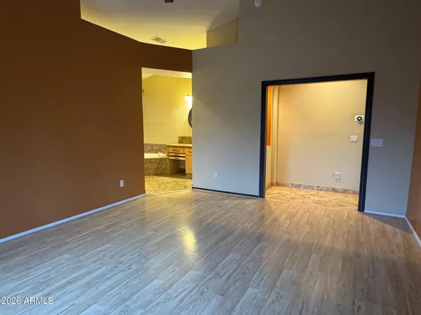 an empty room with wooden floor and entrance