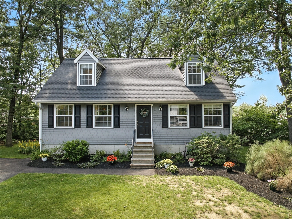 a front view of a house with a yard and trees