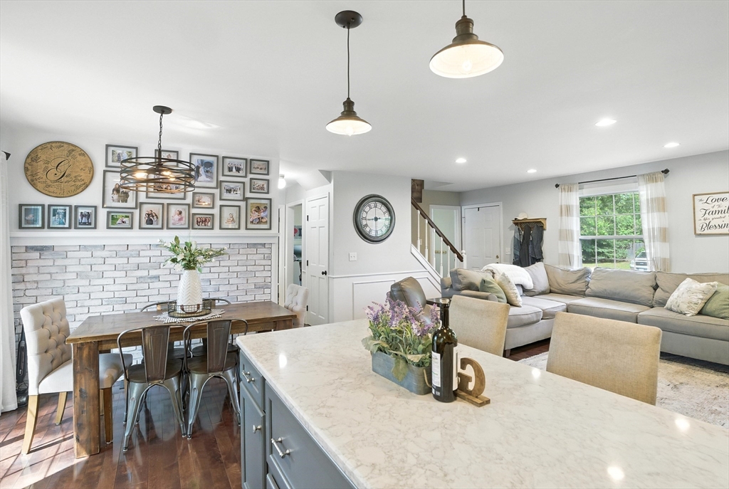 22 Dean Street Hudson, MA 01749 - Photo 11 of 30 a living room with couches a dining table chairs and couches with wooden floor