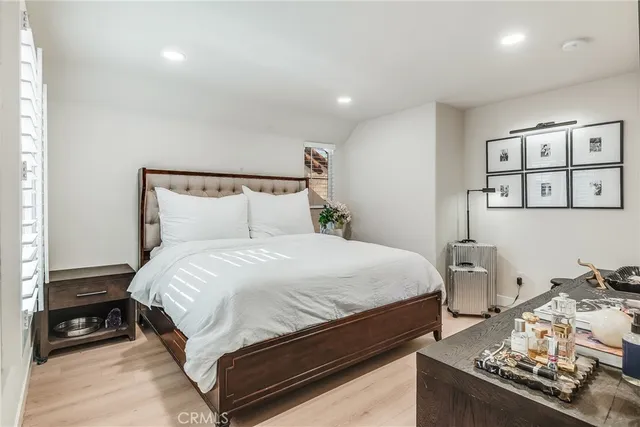 a bedroom with a bed and wooden floor