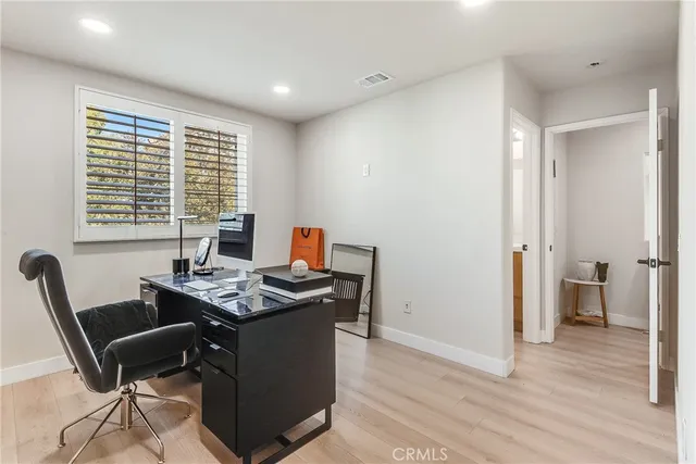 a view of a workspace with furniture and a window