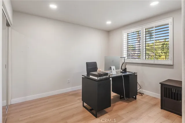 a view of a workspace with furniture and a window