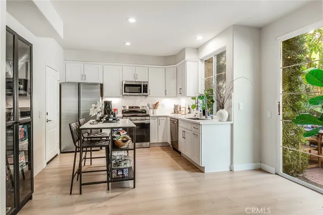 a kitchen with a sink a counter top space stainless steel appliances and cabinets
