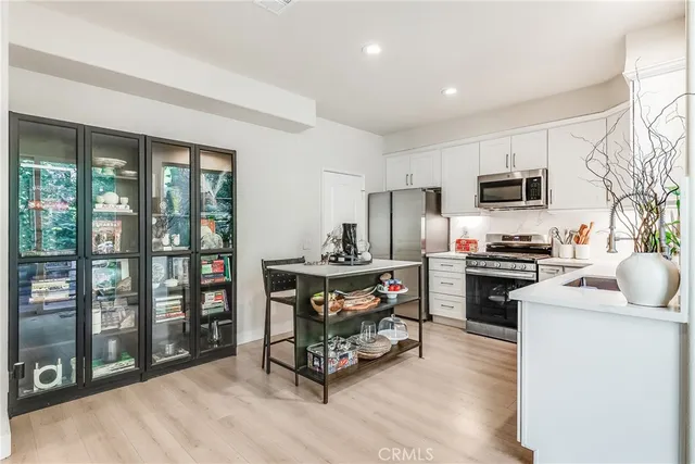 a kitchen with stainless steel appliances a stove a sink and a refrigerator