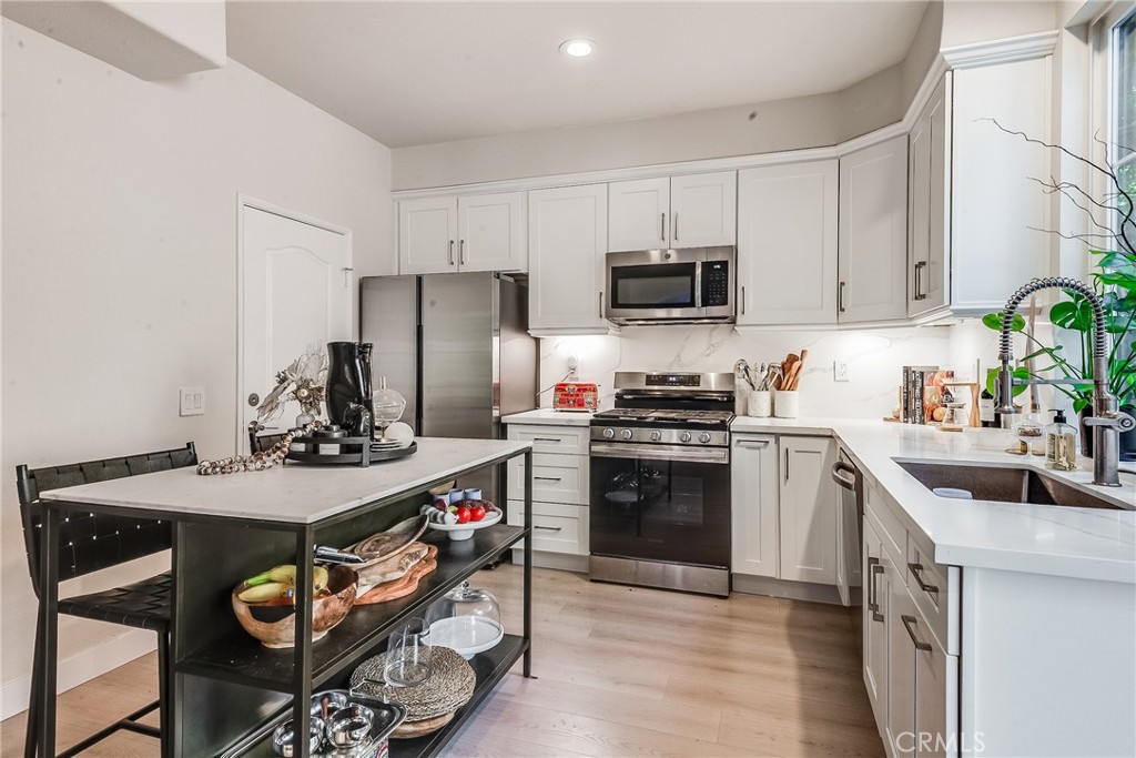 23301 Montecito Place Valencia, CA 91354 - Photo 10 of 41 a kitchen with stainless steel appliances granite countertop a sink stove and refrigerator