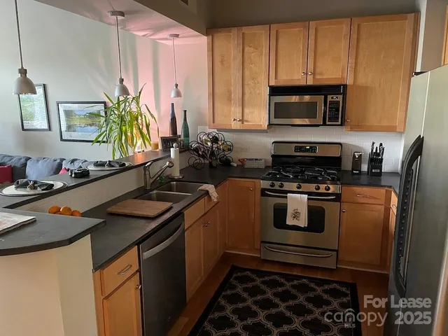 a kitchen with stainless steel appliances a stove a sink and a microwave