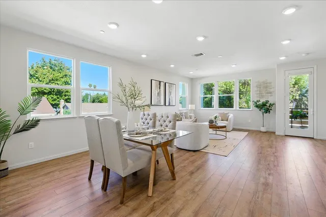 a kitchen with kitchen island a dining table chairs stainless steel appliances and cabinets
