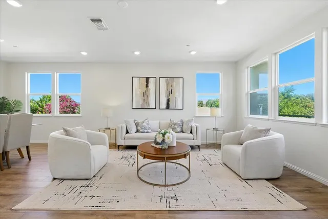a living room with furniture and a wooden floor